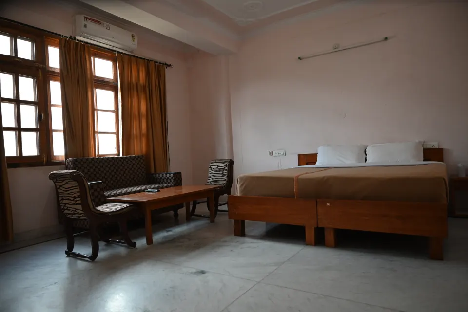 Deluxe Room interior with bed, sofa and windows